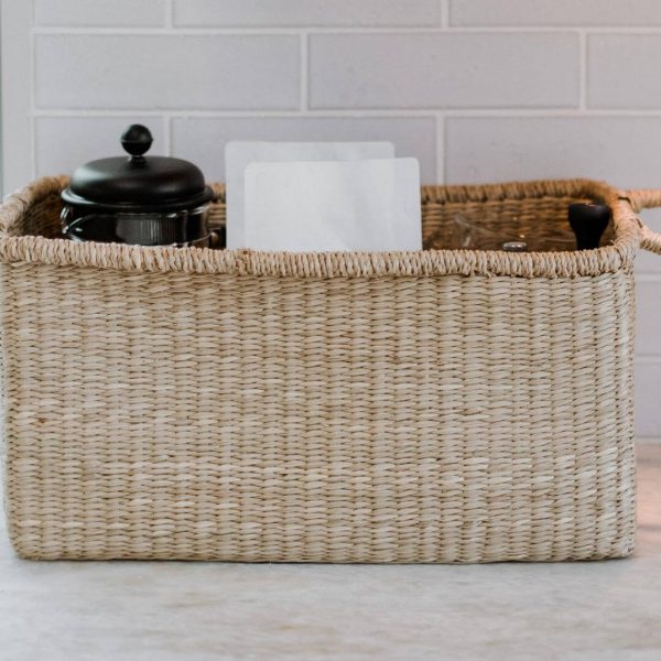 Individually handmade by skilled Vietnamese craftspeople, this seagrass storage tote with handles adds a wonderful rustic touch to any room.